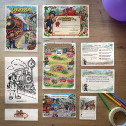 Alle onderdelen van de Treinen Speurtocht op tafel: voorblad, diploma, oplossingskaart, kleurplaat, opdrachtkaarten, speluitleg, uitnodigingen en pijlen